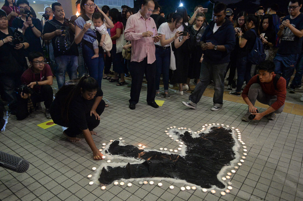 Volunteers perform during a candlelight vigil for the late Teoh Beng Hock at Plaza Masalam in Shah Alam July 13, 2019. — Picture by Mukhriz Hazim
