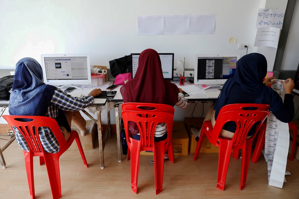 Workers receive online orders for Anurak Sareuthai, who sells dried seafood products during Facebook live events, in Satun province, southern of Thailand, May 30, 2019. — Reuters pic