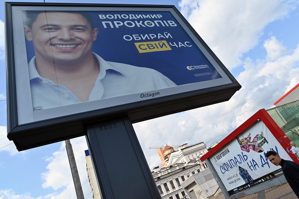 A man walks past a campaign billboard depicting Volodymyr Prokopiv, candidate of the u00e2u20acu02dcEuropean Solidarityu00e2u20acu2122 party founded by Ukrainian former President, in Kiev on July 18, 2019, ahead of the country's parliamentary election on July 21. u00e2u20acu201d AFP pic    