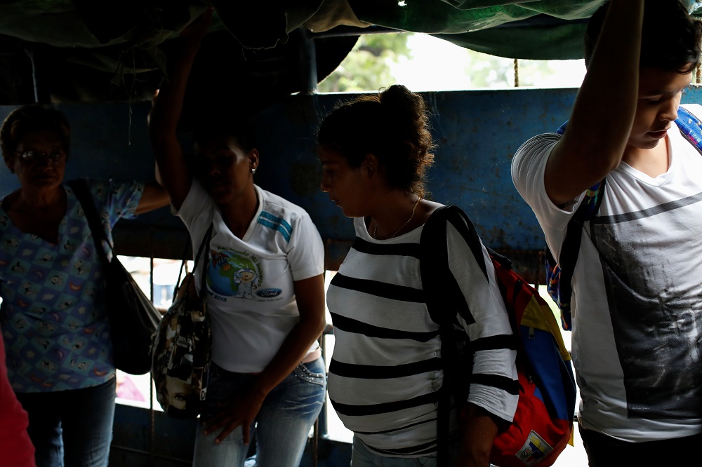 A pregnant woman rides on a cargo truck used as public transportation in Valencia, Venezuela July 11, 2018. u00e2u20acu201d Reuters pic 