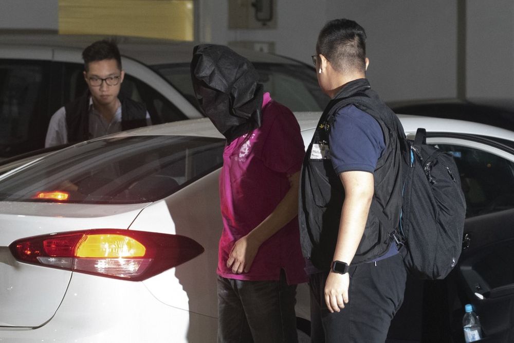 A man (pink shirt) is taken away by police after he was arrested for illegal assembly in the district of Yuen Long in Hong Kong on July 22, 2019, where there was a vicious assault on pro-democracy protesters by suspected triad gangsters. u00e2u20acu201d AFP pic