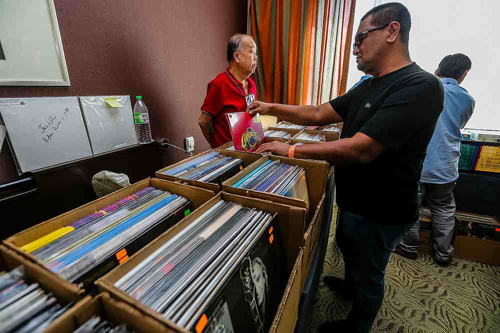 AV enthusiasts scrolling through vintage records at one of the exhibits at the KL International AV Show 2019. u00e2u20acu201d Picture by Firdaus Latif