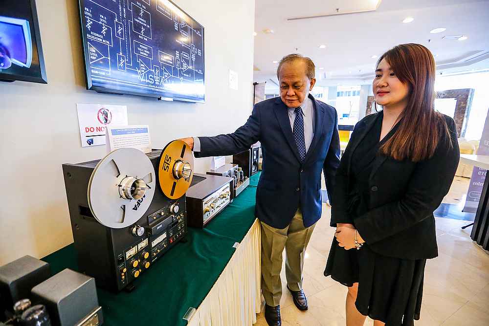 Chairman of the KL International AV Show, Dick Tan, showing off a vintage audio player to Vistana KL Hotel assistant sales manager Sammy Liew during the first day of the exhibition. — Picture by Firdaus Latif