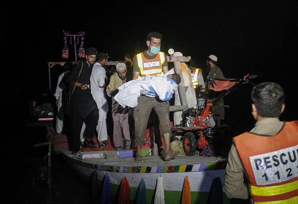 A Pakistani rescue worker carries the body of a child after a boat capsized in the Indus River in the Haripur district July 3, 2019. u00e2u20acu201d AFP pic