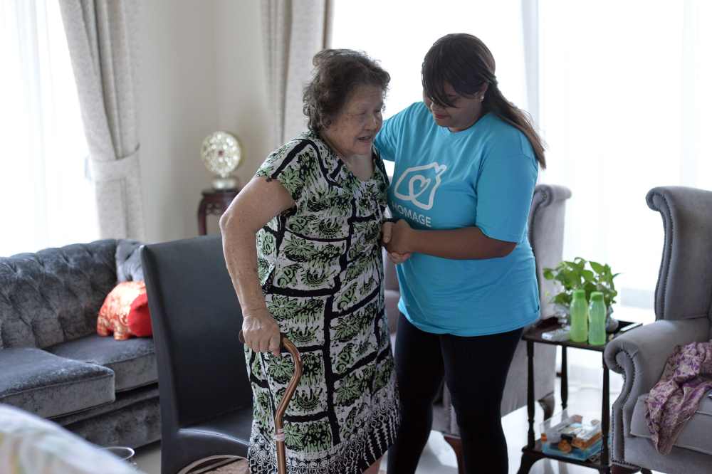 Jeyyanthi (in blue) says that helping a CR to live comfortable lives by aging in place is one of the many rewarding aspects of the job. — Picture by Mukhriz Hazim