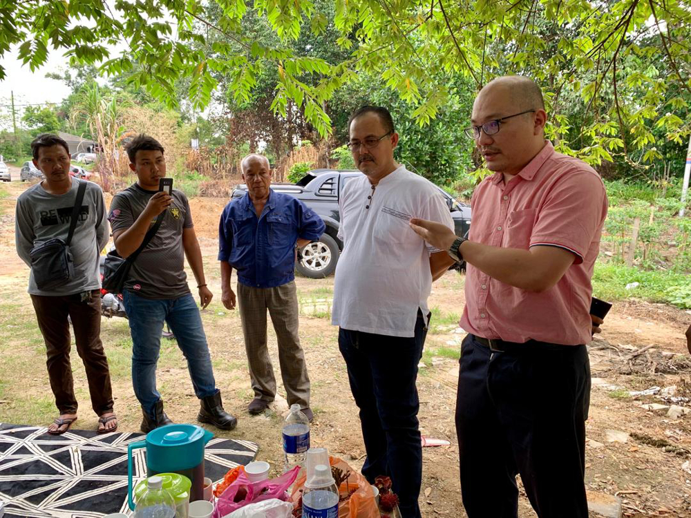 Perling assemblyman Cheo Yee How (right) giving advise to the villagers on the recent incident where a house was accidentally demolished in Kampung Bakar Batu in Perling July 25, 2019. — Picture by Ben Tan