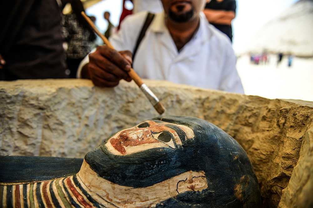 A man brushes off dust from a sarcophagus, part of a new discovery carried out almost 300 metres south of King Amenemhat II's pyramid at Dahshur necropolis. u00e2u20acu201d AFP pic