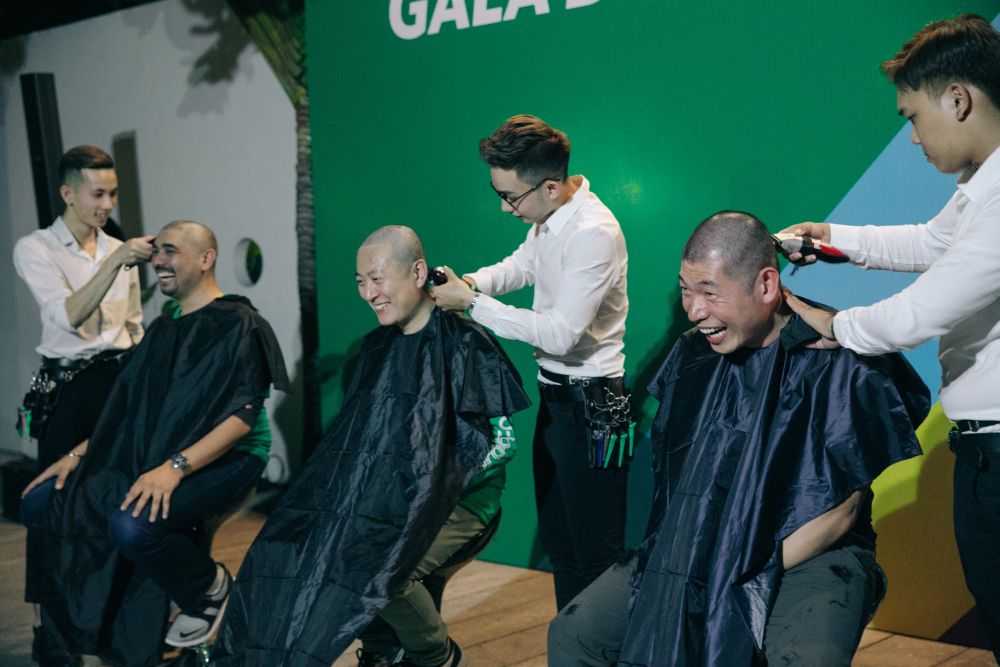 Grab co-founder and chief executive officer Anthony Tan (right) and two other “Grabbers” shave their heads to support children with cancer. — Picture via LinkedIn/anthony-tan