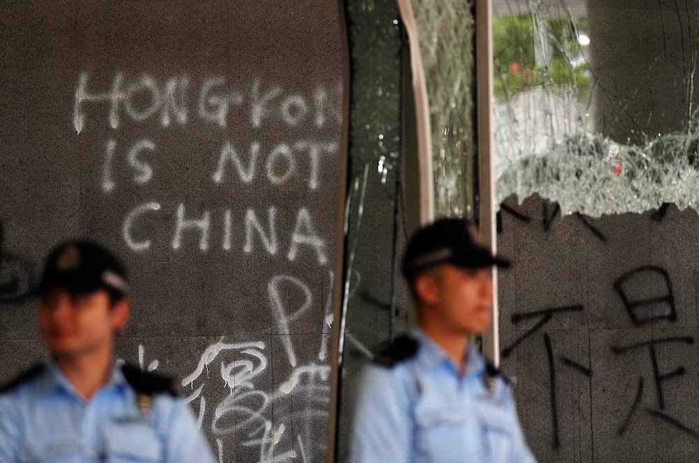 Policemen stand in front of graffiti on the walls of the Legislative Council, a day after protesters broke into the building in Hong Kong July 2, 2019. u00e2u20acu201d Reuters pic