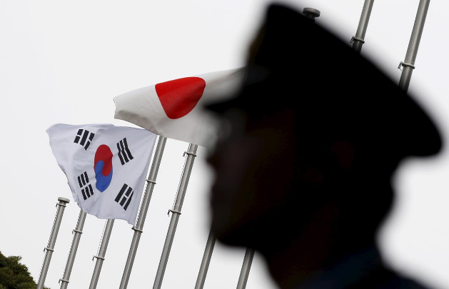 A police officer stands guard near Japan and South Korea national flags at hotel, where South Korean embassy in Japan is holding the reception to mark the 50th anniversary of normalisation of ties, Tokyo June 22, 2015. u00e2u20acu201d Reuters pic