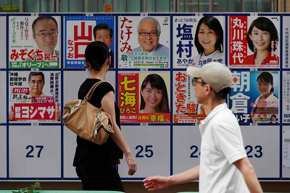 People walk past election campaign posters outside a voting station during Japan's upper house election in Tokyo July 21, 2019. u00e2u20acu201d Reuters pic