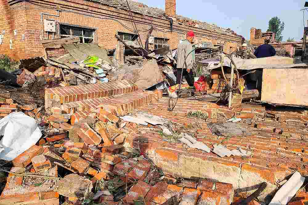 People walking on walls and buildings damaged by a tornado in Kaiyuan, in China's northeastern Liaoning province July 3, 2019. u00e2u20acu201d AFP pic