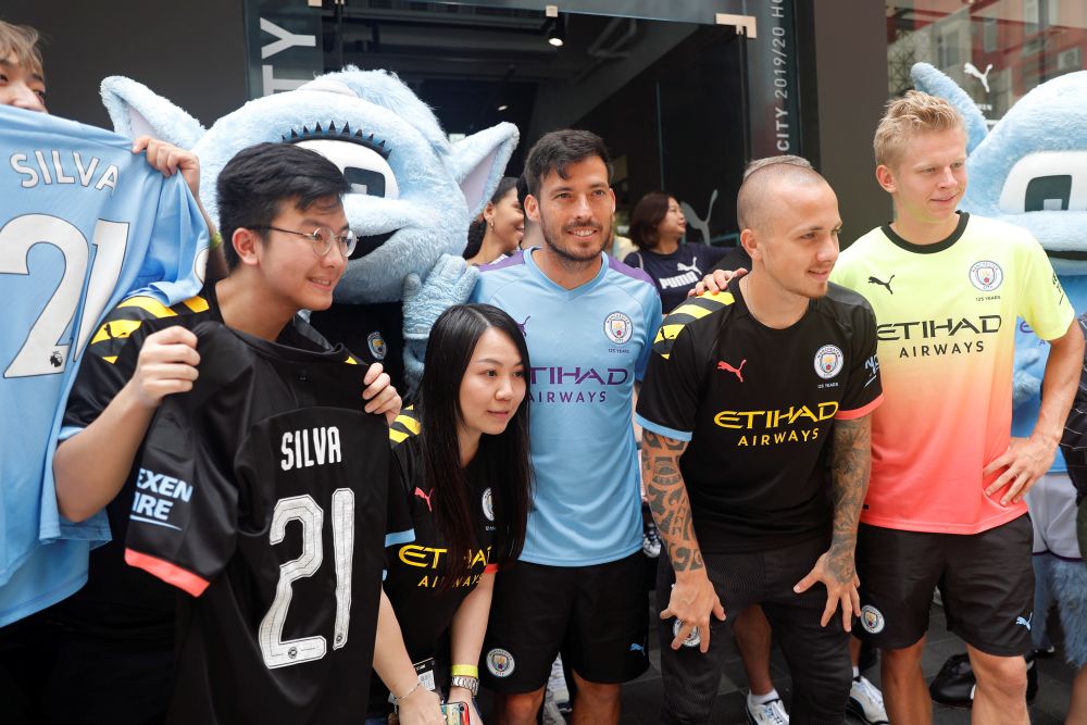 Manchester Cityu00e2u20acu2122s David Silva (centre) poses with teammates Angelino (second from right), Oleksandr Zinchenko (right), and fans during a promotional event in Hong Kong July 23, 2019. u00e2u20acu2022 Reuters pic