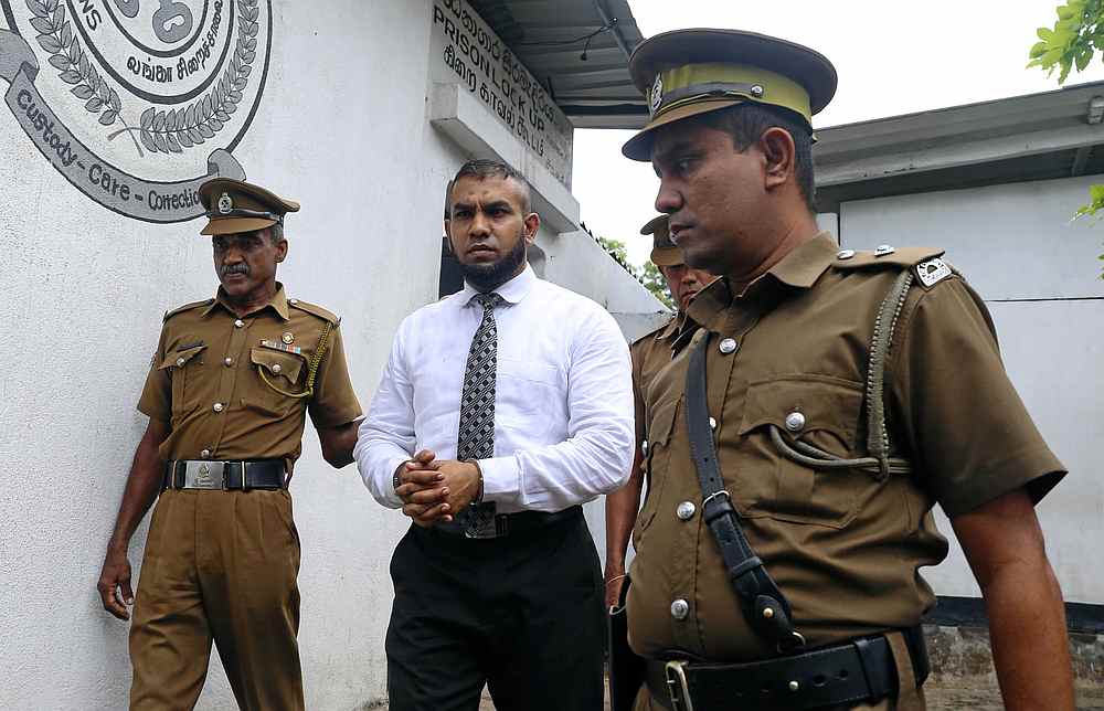Muslim doctor Segu Shihabdeen Mohamed Shafi (centre) is escorted by prison officers at the Magistrate Court in Kurunegala, Sri Lanka July 25. 2019. u00e2u20acu201d Reuters pic