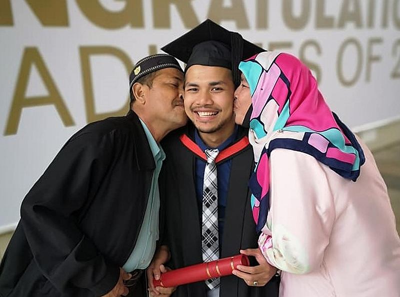 Muhammad Afiq Ismail (centre) with his parents at his graduation ceremony at University of Essex in the UK. u00e2u20acu201d Picture via Facebook/khairulaimanhamdan
