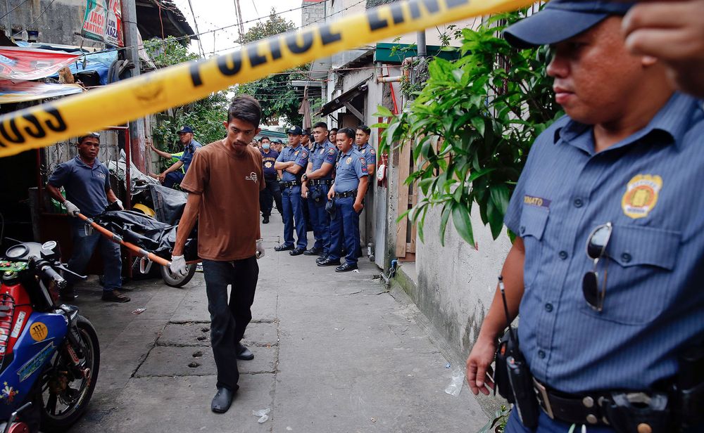 Funeral workers carry the bodies of pedicab drivers Norberto Maderal and George Avancena. Maderalu00e2u20acu2122s nephew said his uncle was unarmed and begging for his life before the police fired. u00e2u20acu201d Reuters file pic