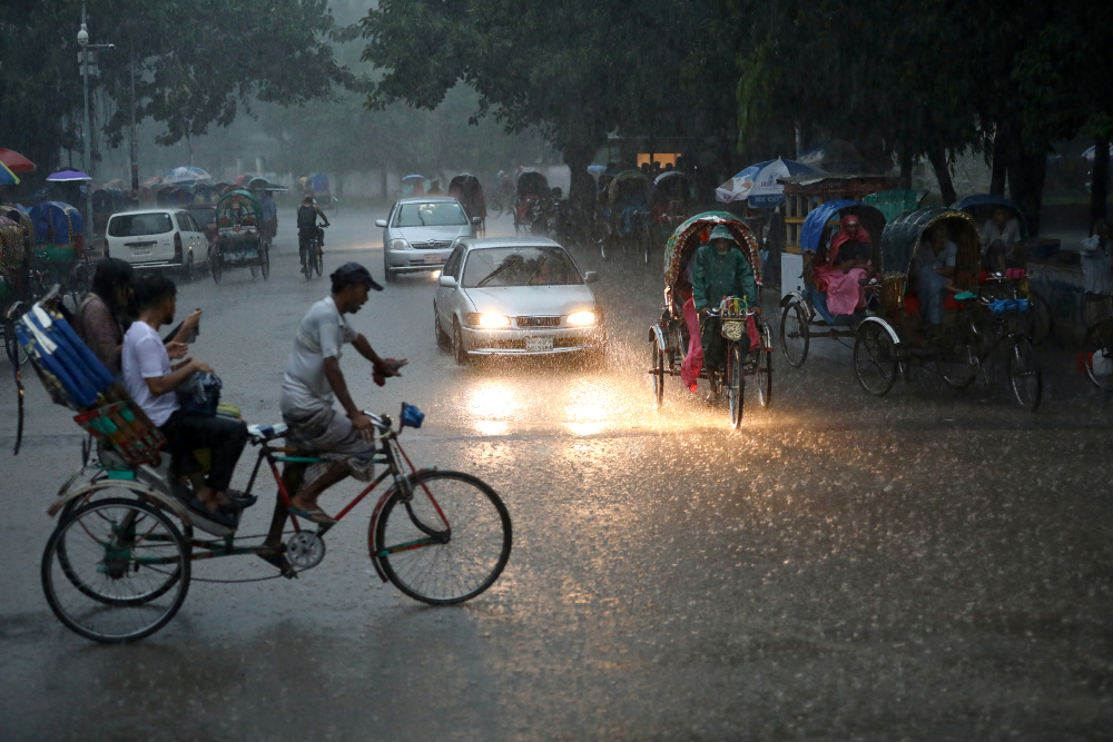 Vehicles are seen on a street during heavy rain in Dhaka July 13, 2019. u00e2u20acu201d Reuters