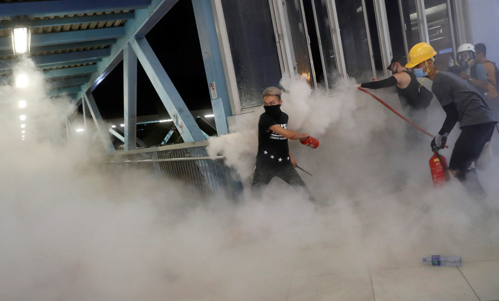 A protester throws a fire extinguisher as he tries to stop riot police to get inside a train station during a protest against the Yuen Long attacks in Yuen Long, New Territories, Hong Kong July 27, 2019. u00e2u20acu201d Reuters pic