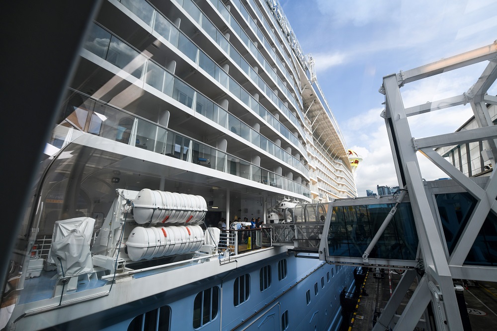 In this file photo taken on May 21, 2019, passengers pass the port boarding bridge connected to the Royal Caribbean International cruise ship Spectrum of the Seas while the vessel is docked at the Marina Bay Cruise Centre in Singapore. u00e2u20acu201d AFP pic        