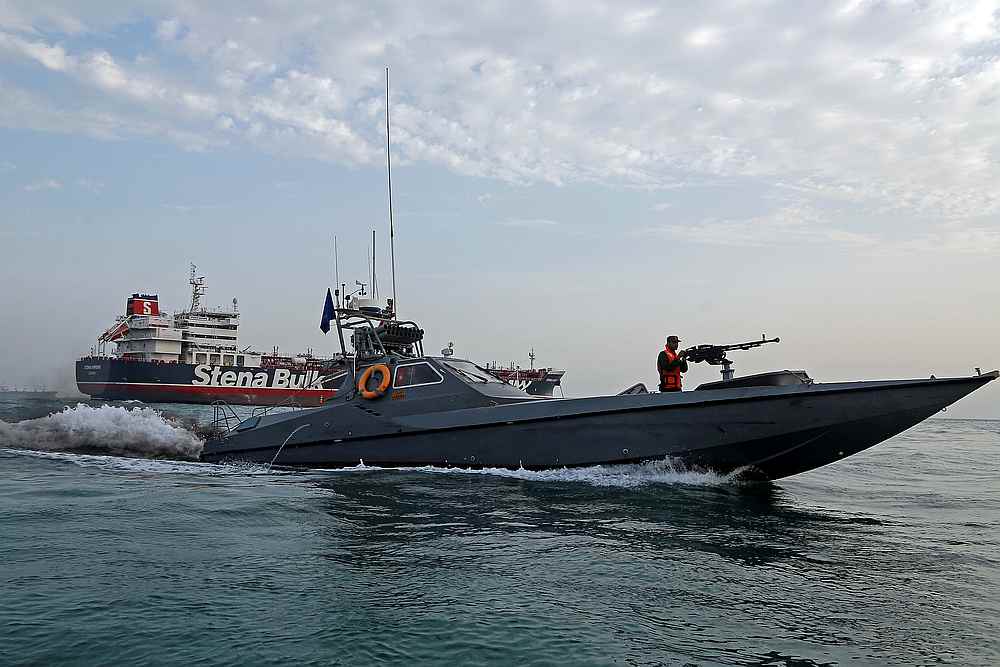 A boat of the Iranian Revolutionary Guard sails next to British-flagged Stena Impero at Bandar Abbas port, July 21, 2019. u00e2u20acu201d Iran, Mizan News Agency/Wana handout via Reuters