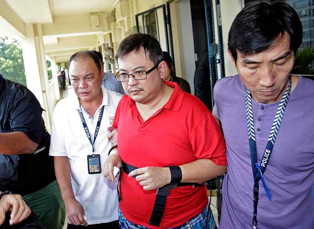 Woodlands murder suspect Teo Ghim Heng (second from right) being escorted back to the crime scene on February 10, 2017. u00e2u20acu201d TODAY pic