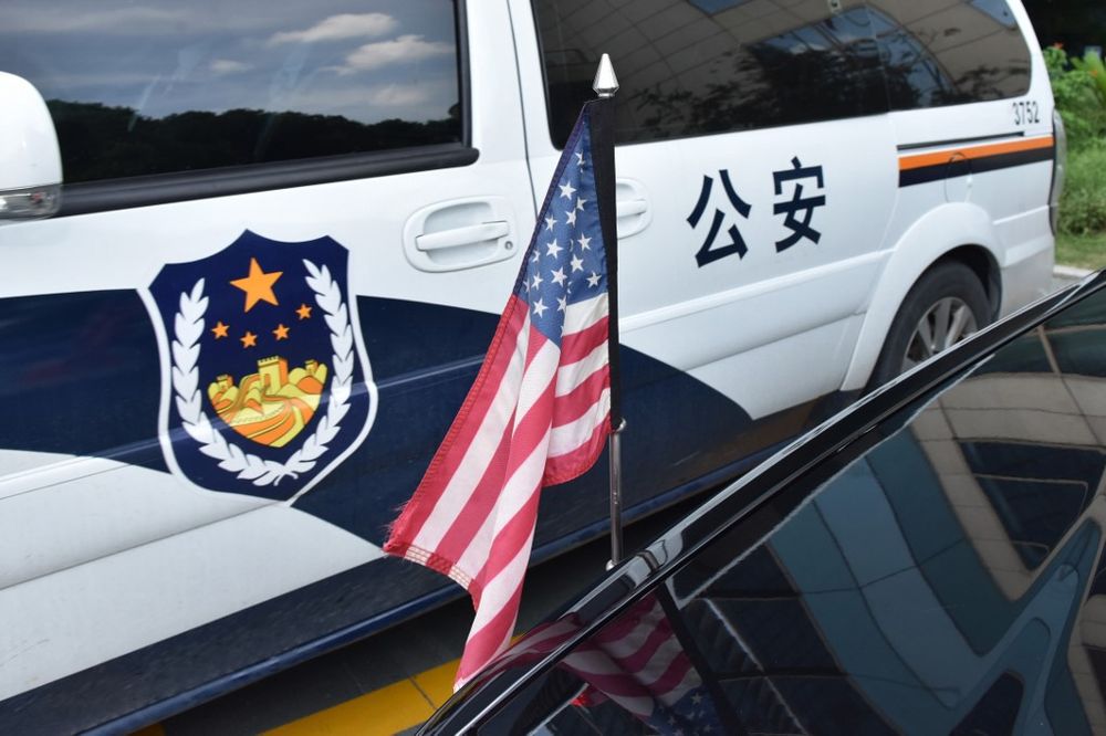A US flag hangs from a US consulate car, next to a Chinese police van outside a hotel after a convoy of cars believed to be carrying US trade negotiators arrived in Shanghai, July 30, 2019. u00e2u20acu201d AFP pic