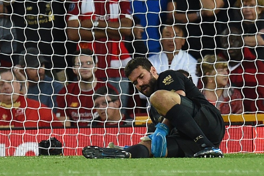 Liverpoolu00e2u20acu2122s goalkeeper Alisson Becker waits to receive medical attention during the English Premier League football match with Norwich City at Anfield in Liverpool August 9, 2019. u00e2u20acu201d AFP pic