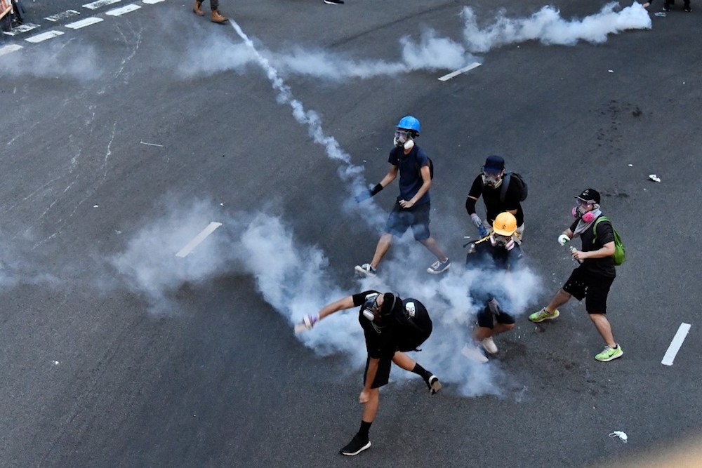 Protesters throw back tear gas cannisters fired by the police in Tai Wai in the New Territories of Hong Kong August 10, 2019. u00e2u20acu201d AFP pic