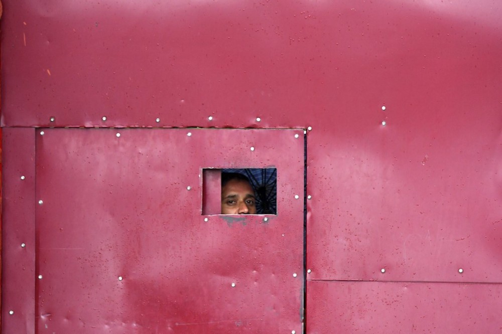 A worker looks through the gate of a closed school in Srinagar August 19, 2019. u00e2u20acu201d AFP pic
