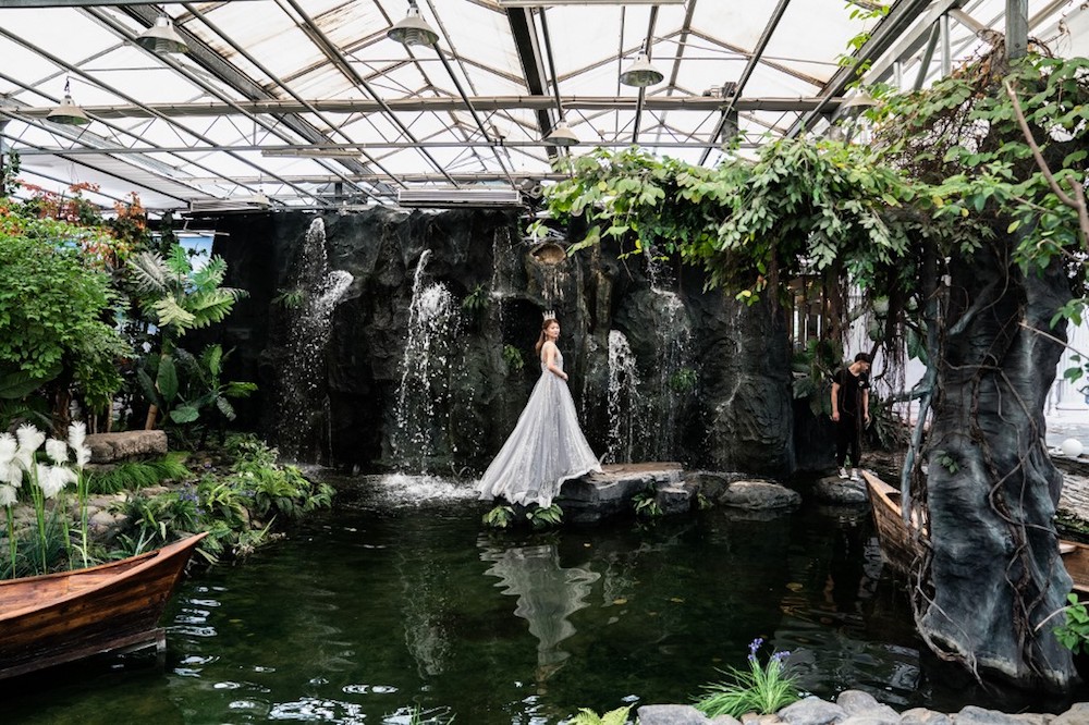A bride poses for a picture on a waterfall-themed set during her pre-wedding photo shoot at the Love Story in Rome Studio in Beijing June 20, 2019. — AFP pic