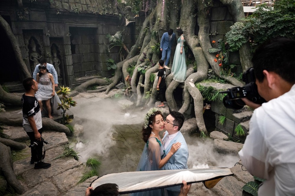 Couples pose for pictures on an Angkor-Wat themed set for their pre-wedding photo shoot at the Love Story in Rome Studio in Beijing June 11, 2019. u00e2u20acu201d AFP pic