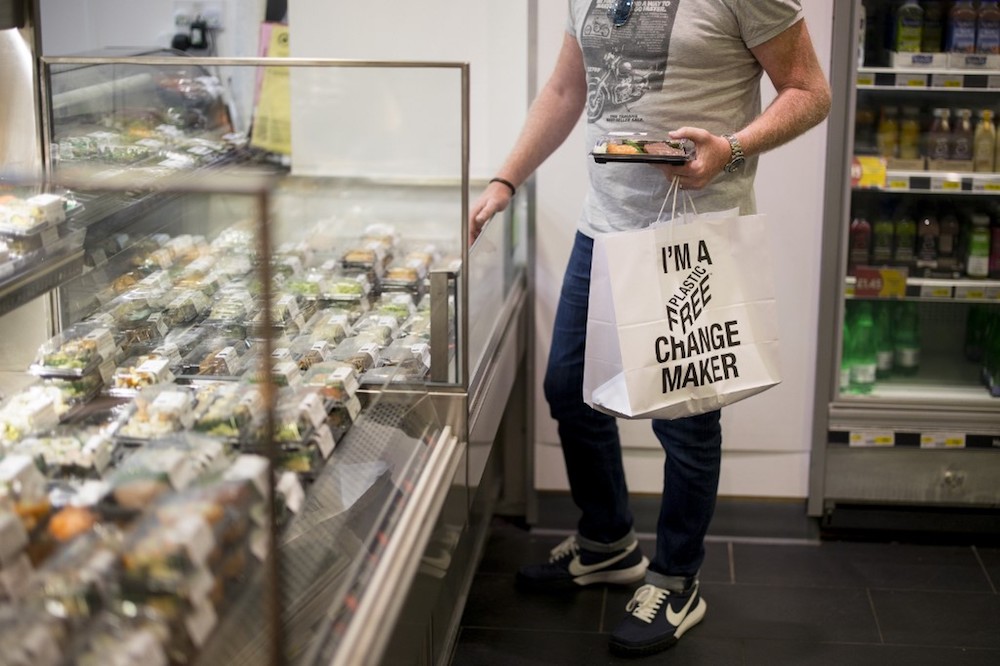 A shopper holds a paper bag with a slogan promoting plastic-free packaging shops at Budgens supermarket in Belsize Park, north London July 2, 2019. u00e2u20acu201d AFP pic