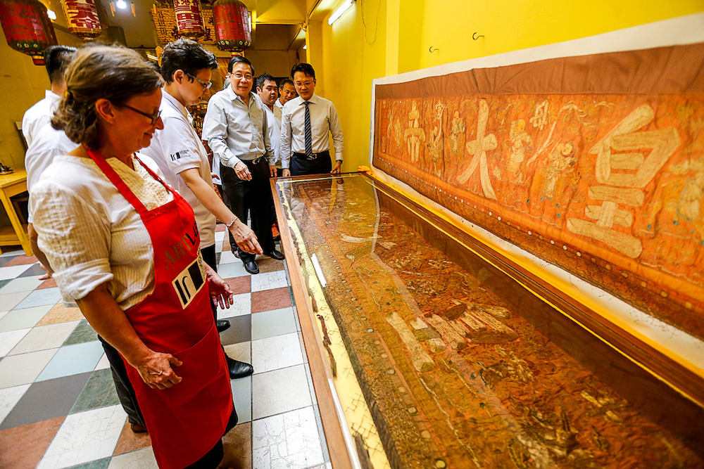 Principle Textiles Conservator of Artlab Australia Kristin Phillips (centre) reveals the restored textile to public during a press conference on the Textiles Conservation Community Project in Georgetown August 2, 2019. u00e2u20acu201d Picture by Sayuti Zainudin