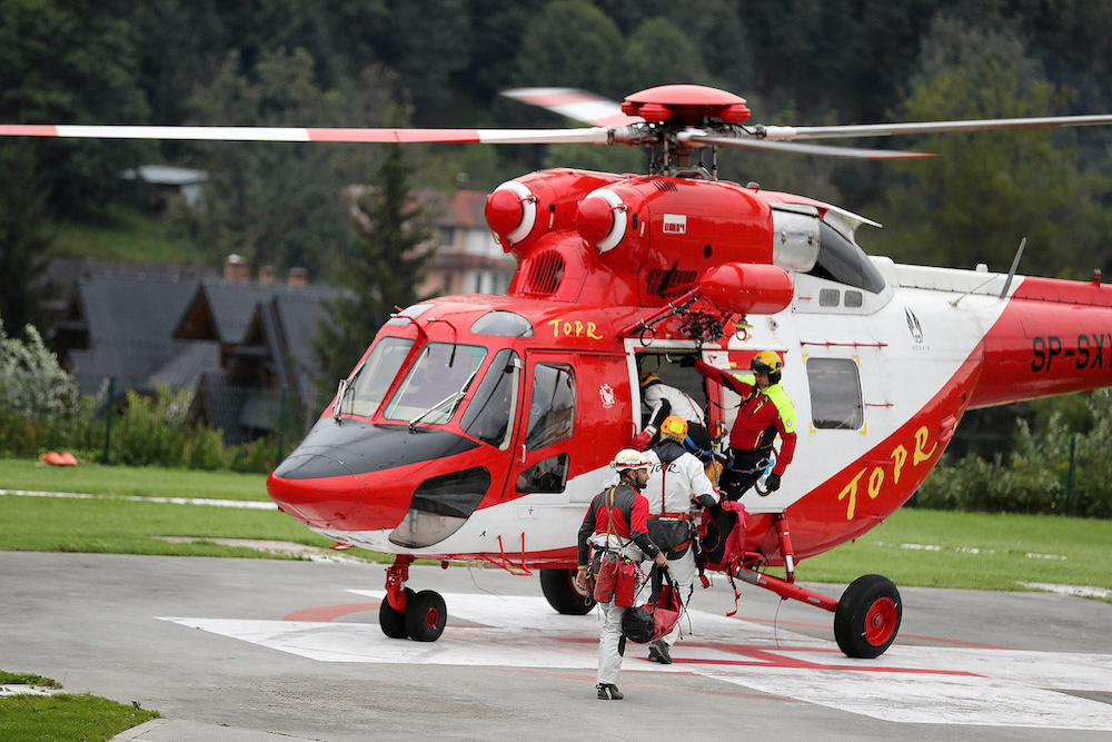 Mountain rescue team (TOPR) members board a helicopter in Zakopane, Poland August 18, 2019, to join the search operation for two cave climbers trapped in the Tatra mountains. u00e2u20acu201d Agencja Gazeta/Marek Podmokly handout via Reuters