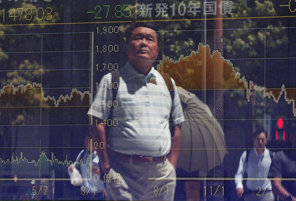 Passersby are reflected on a screen displaying graphs of market indices outside a brokerage in Tokyo August 6, 2019. u00e2u20acu201d Reuters pic