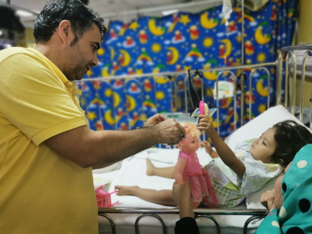 Afghan refugee Lutfullah Ahmad Hussain plays with his daughter, who has leukaemia, in a hospital in Kuala Lumpur July 22, 2019. — Thomson Reuters Foundation pic