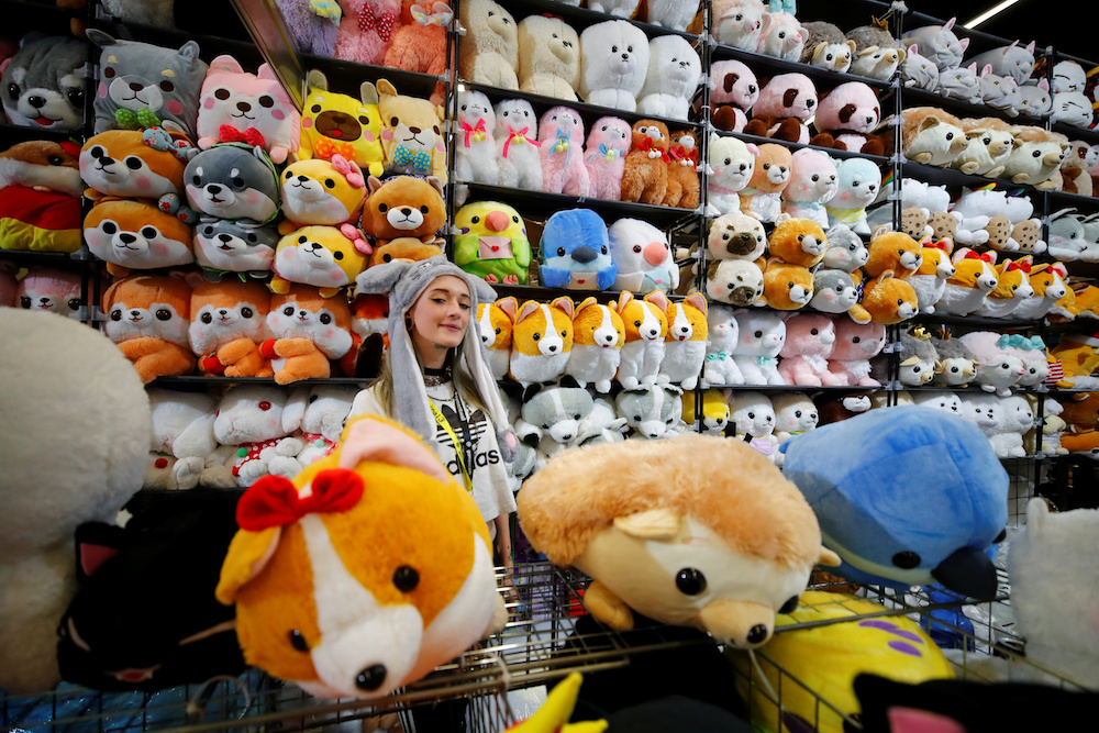 A vendor stands amid plush toys representing various characters from computer games during Gamescom in Cologne August 20, 2019. — Reuters pic