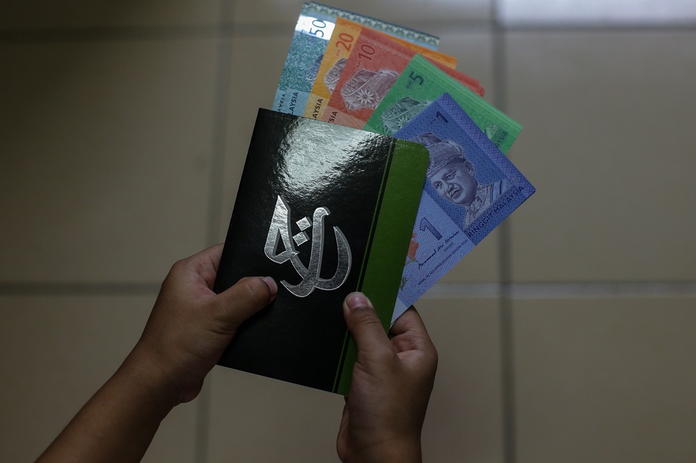 The Lembaga Tabung Haji logo is seen on a bank book in this photo taken in Kuala Lumpur August 4, 2019. u00e2u20acu201d Picture by Ahmad Zamzahuri