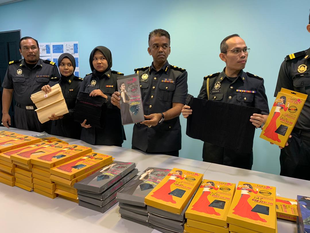 Johor Domestic Trade and Consumer Affairs Ministry enforcement chief Zubir Hamsa (fourth from left) holding-up the popular brand imitation corsets at the ministryu00e2u20acu2122s state officemin Johor Baru today. u00e2u20acu201d Picture by Ben Tan