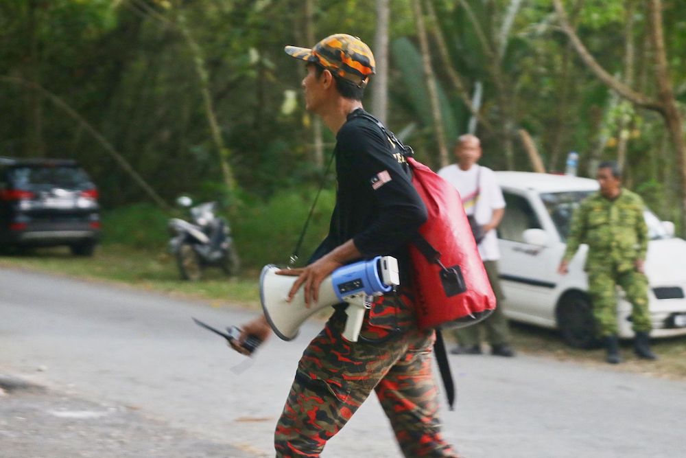 A rescuer holds a bullhorn while participating in the search for missing Irish teen Nora Anne Quoirin in the jungle near Seremban August 8, 2019. — Picture by Ahmad Zamzahuri