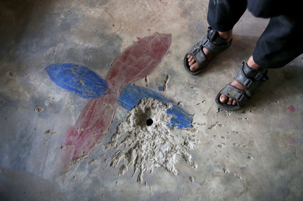 A boy stands next to a crater on the floor of his house caused by a device that according to family looked like a toy in the village of Jabri in Pakistan-administrated Kashmir. u00e2u20acu201d Reuters picnn
