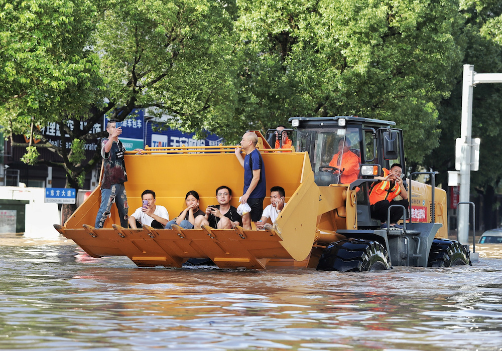 Rescue workers evacuate stranded residents with a bulldozer on a flooded street after typhoon Lekima hit Taizhou, Zhejiang province, China August 11, 2019. u00e2u20acu201d Reuters picnn