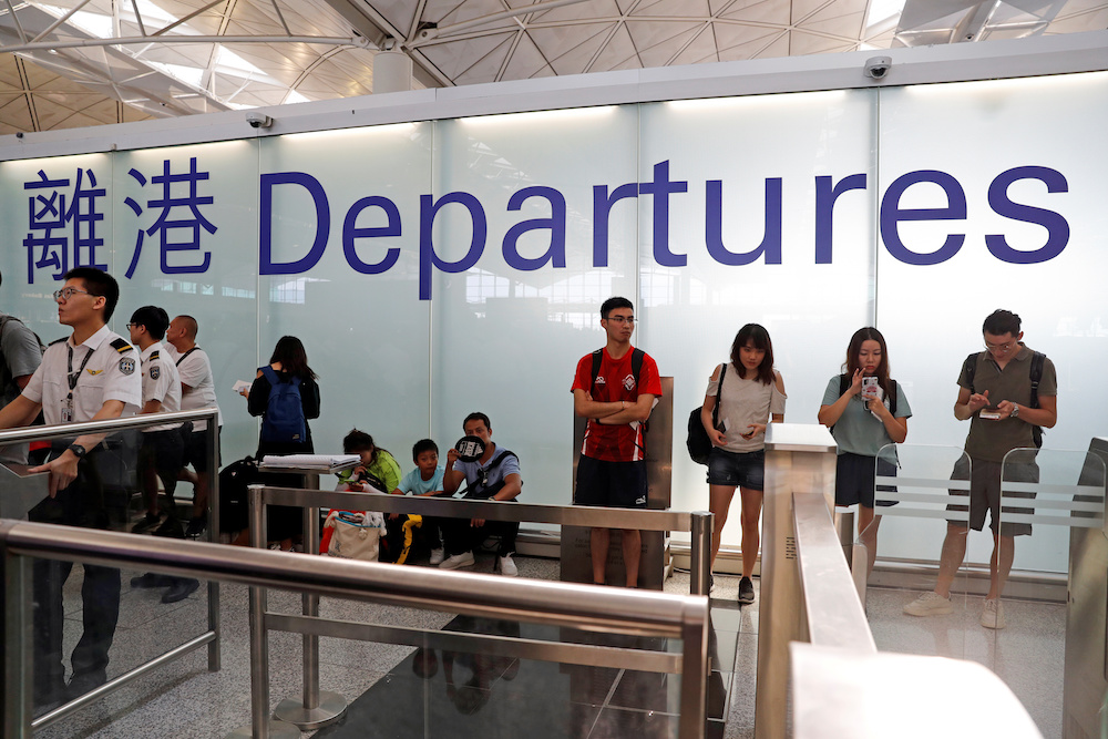 People are seen near a closed security gate as anti-extradition bill protesters attend a mass demonstration after a woman was shot in the eye during a protest at Hong Kong International Airport, in Hong Kong August 12, 2019. u00e2u20acu201d Reuters picnn