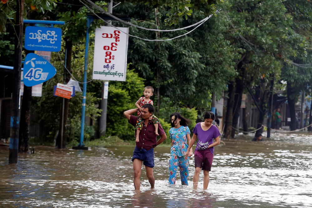 A familiy walk along a flooded street in Theinzeik, Mon state, Myanmar, August 11, 2019. u00e2u20acu201du00c2u00a0Reuters pic