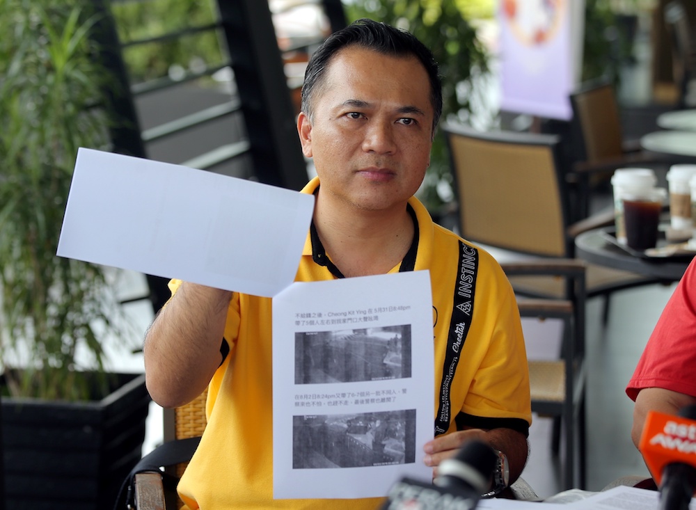 Teng Hwa Lin shows pictures of his friend allegedly making threats and demanding money in front of his house in Tambun August 14, 2019. u00e2u20acu201d Picture by Farhan Najib