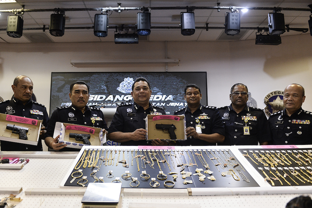 CID Director Datuk Huzir Mohamed poses for pictures with some of the seized jewellery and guns during a press conference at the Selangor Contingent Police Headquarters in Shah Alam August 15, 2019. u00e2u20acu201d Picture by Miera Zulyana