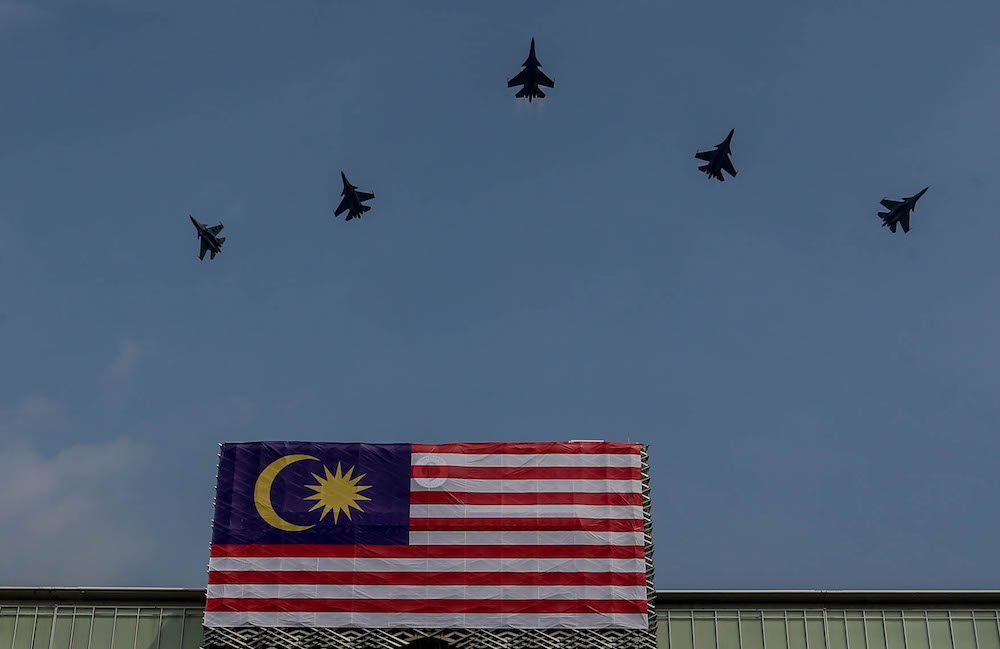Malaysian Air Force fighter jets fly past the Malaysian flag during a National Day rehearsal in Putrajaya August 29, 2019. u00e2u20acu201d Picture by Firdaus Latif
