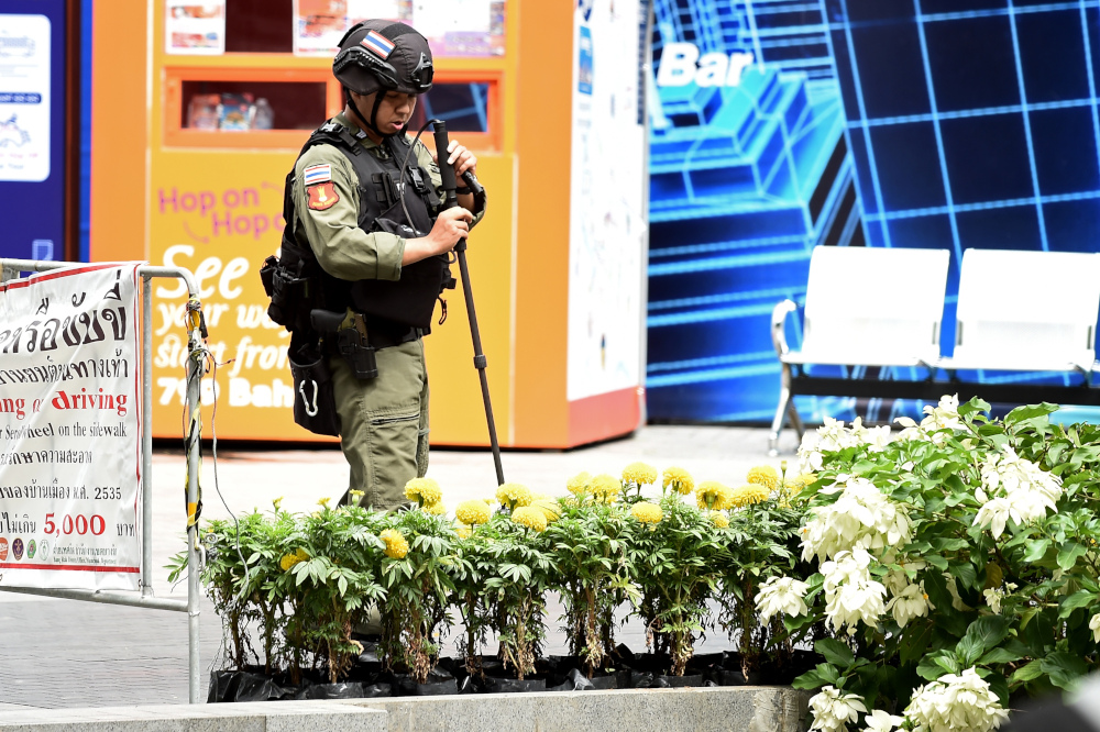 A policeman from the explosive ordinance disposal unit runs a bomb detector through a bed of flowers at the scene of an explosion in Bangkok August 2, 2019. u00e2u20acu201d AFP pic 
