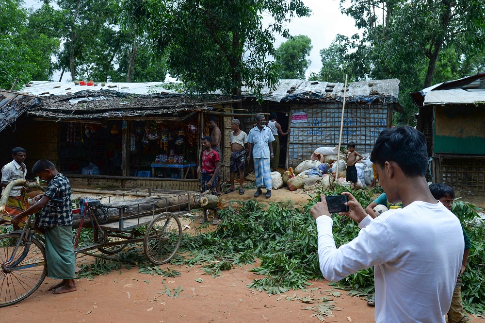 In this picture taken on July 23, 2019, Rohingya youth Mohammad Rafiq (right) uses his mobile phone to take photos at the Kutupalong refugee camp. — AFP pic