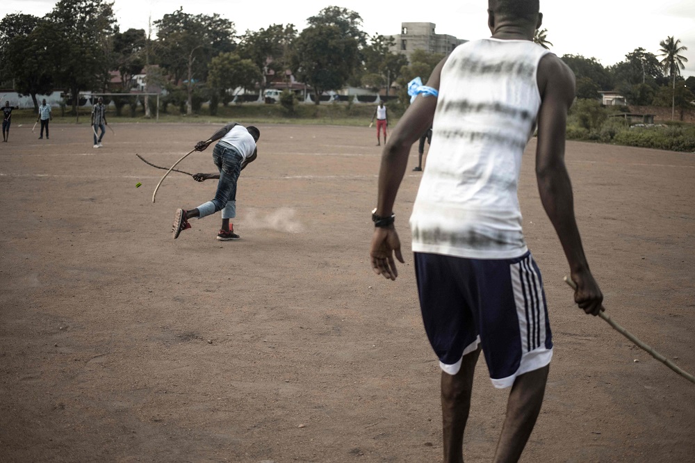A Ngbaba player hits the puck with a wooden stick during a game in Bangui August 8, 2019. u00e2u20acu201d AFP pic  